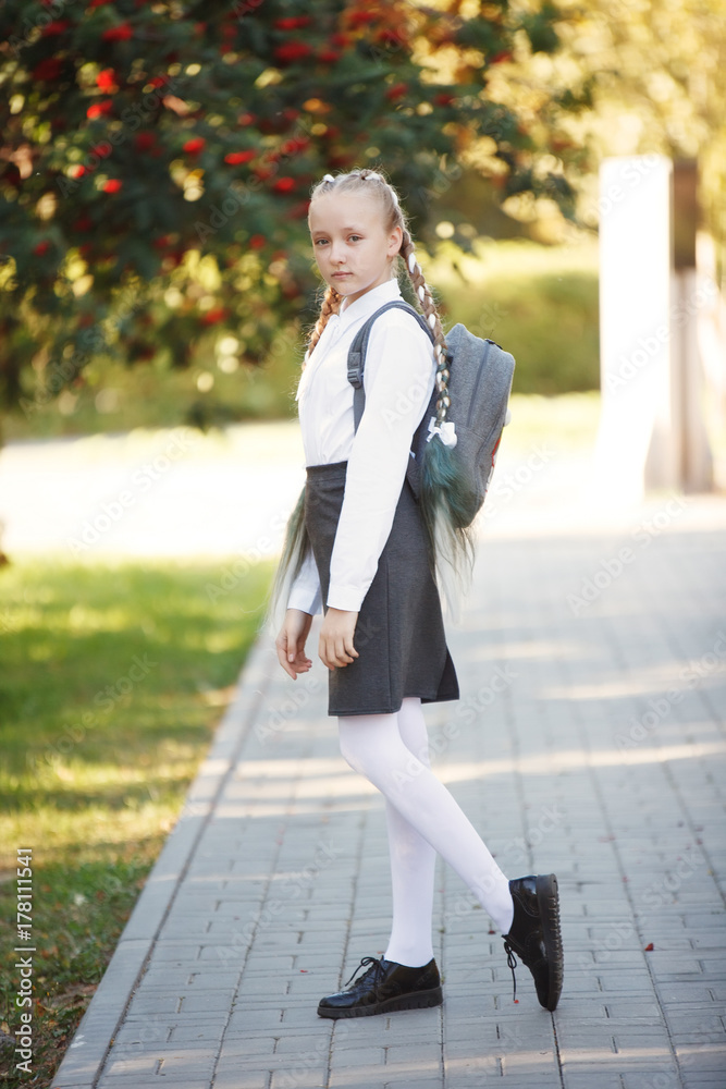 Outdoors portrait of a beautiful tanned teen student girl. Outdoors portrait of a beautiful tanned teen student girl.
