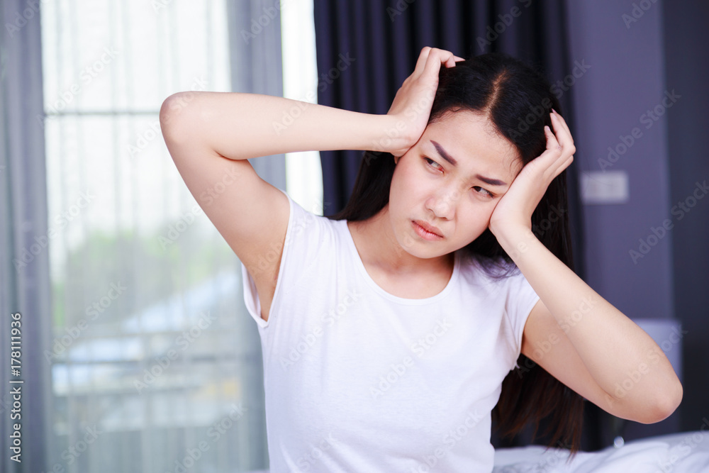 woman with headache on bed in bedroom woman with headache on bed in bedroom