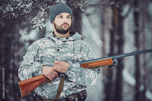 Male hunter in camouflage looking for his target or prey .Winter scene