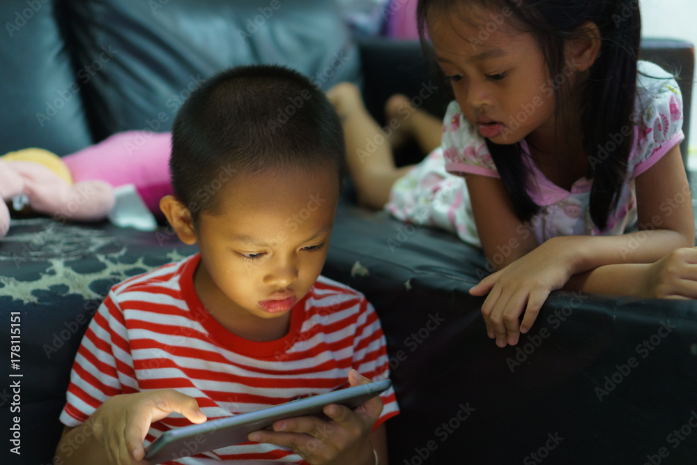 Cropped view of little boy and girl using a digital tablet at home Cropped view of little boy and girl using a digital tablet at home