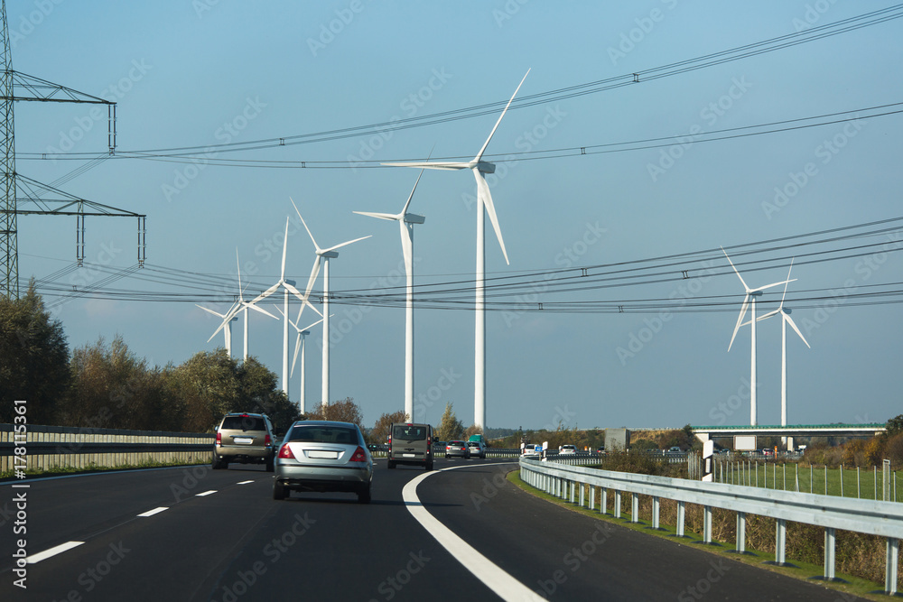 Wind turbines near highway. Clean energy concept. Wind turbines near highway. Clean energy concept.