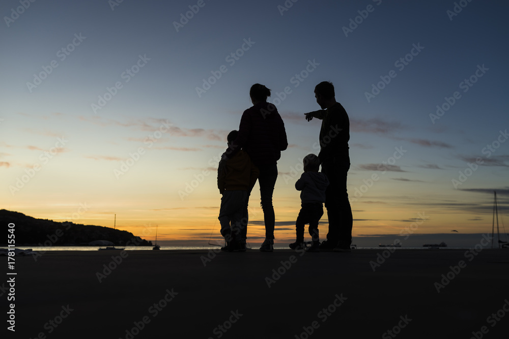 Silhouetted family outdoors looking at the sunset