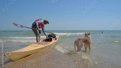 man kayaking with siberian husky dog