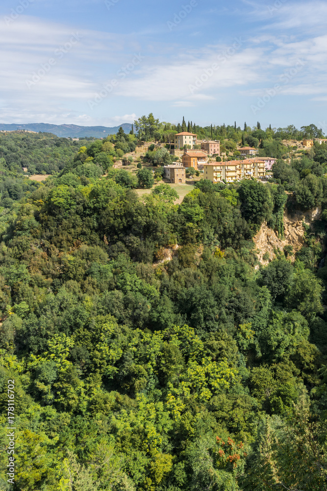 Few houses built on rock in Tuscany Italy with forest around