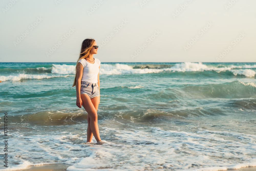 Girl With Long Hair on the background of the sea sunset
