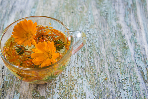 cup of tea with calendula flowers on rustic background/herbal tea