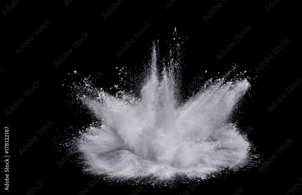 Naklejka premium Splash of white powder over black background.