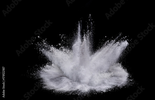 Splash of white powder over black background.