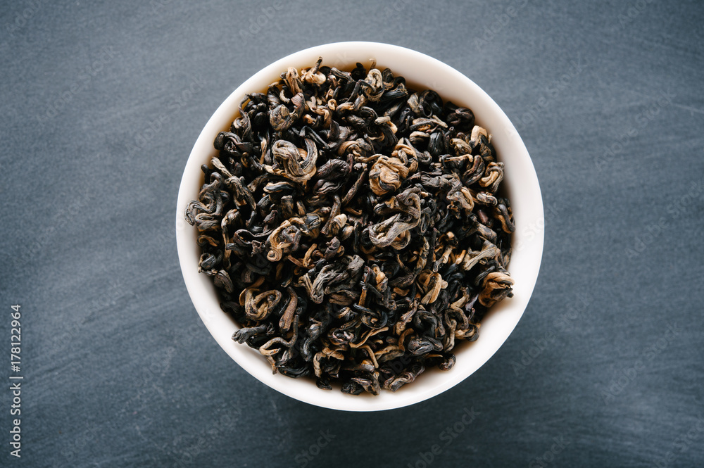 Bowl of Loose Black Chinese Tea Presented on a Black Chalkboard Surface Bowl of Loose Black Chinese Tea Presented on a Black Chalkboard Surface