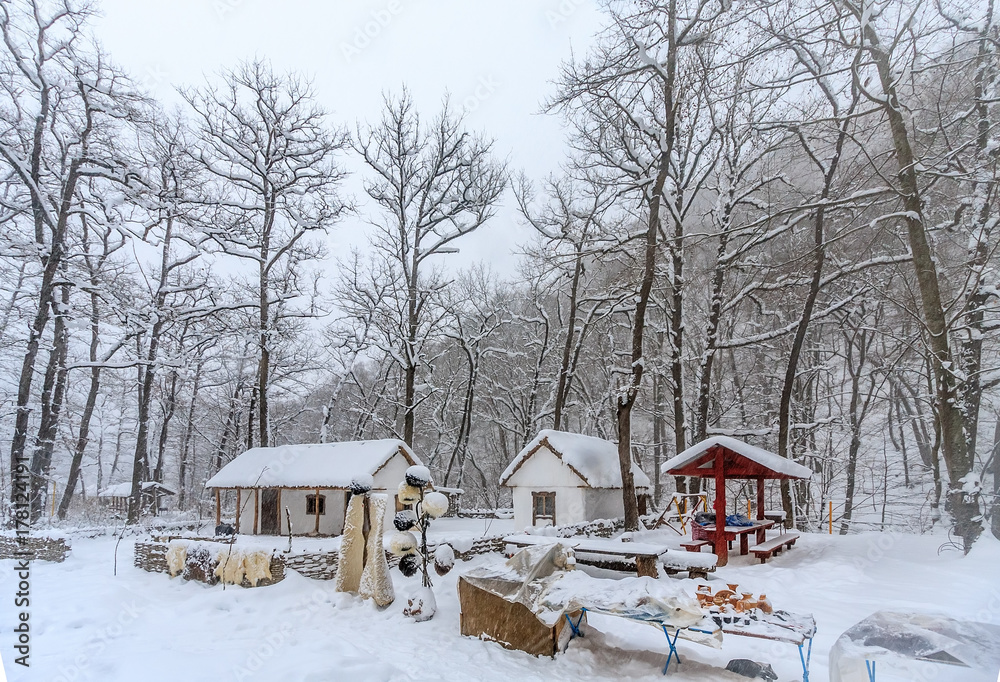 Authentic Adygean national folk's clothes and souvenirs set out for sale by Rufabgo mountain river in snowy winter among bare snow covered trees