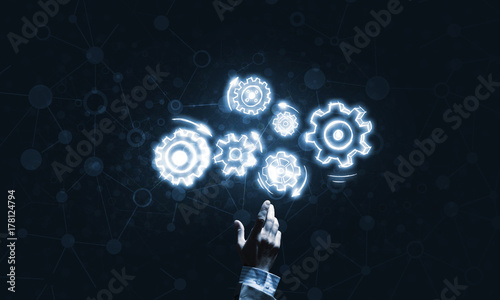 Wallpaper Mural Glowing cogwheel mechanism icon on dark background as symbol of teamwork Torontodigital.ca