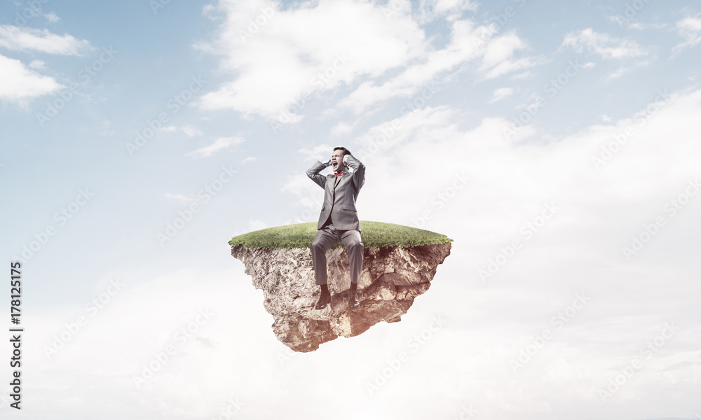 Young man on floating island do not want to hear anything Young man on floating island do not want to hear anything
