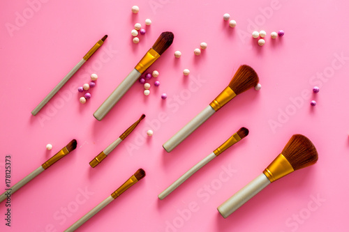 Natural makeup. Ball blushers and brushes pattern on pink background top view