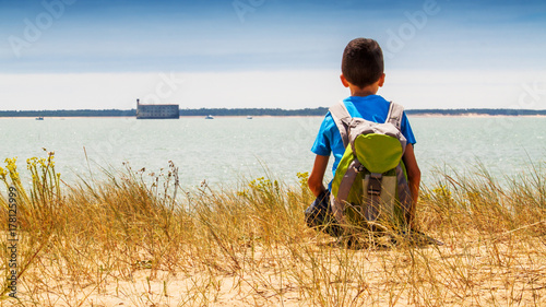 garçon sur la plage regardant fort Boyard photo