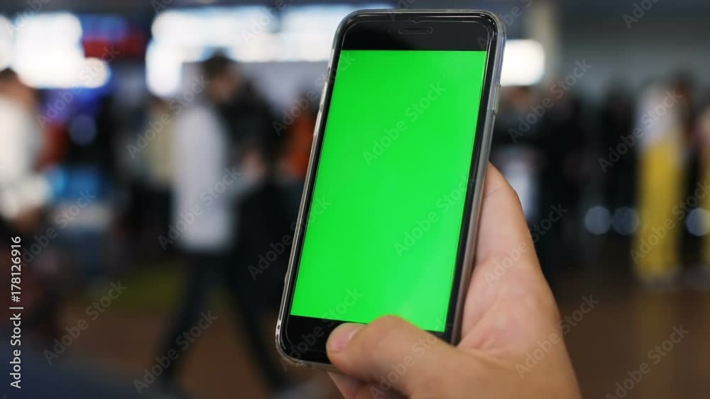 man male traveler holding using mobile smart phone modern tech waiting ready board blurred people background airport floor searching information foreign local flight green screen chromakey chroma key