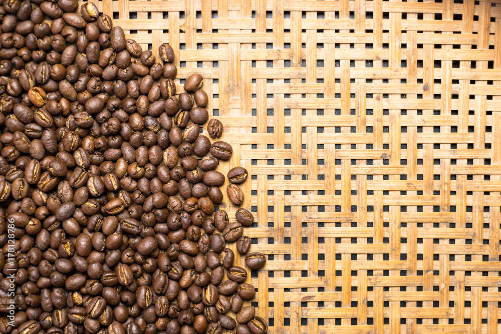 Fototapeta premium Flay lay style, Medium dark Roasted peaberry coffee beans on bamboo handcraft background with copy space.