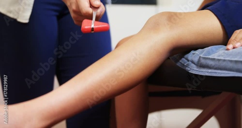 Doctor examining reflexes of patient knee 