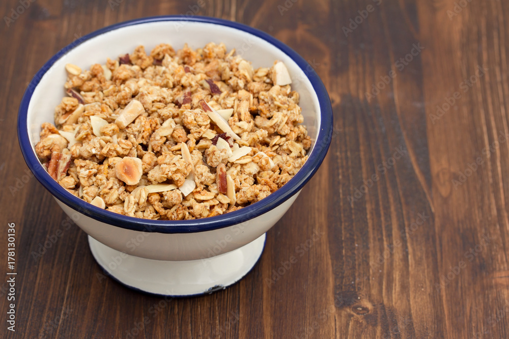granola with nuts in the bowl on wooden background granola with nuts in the bowl on wooden background