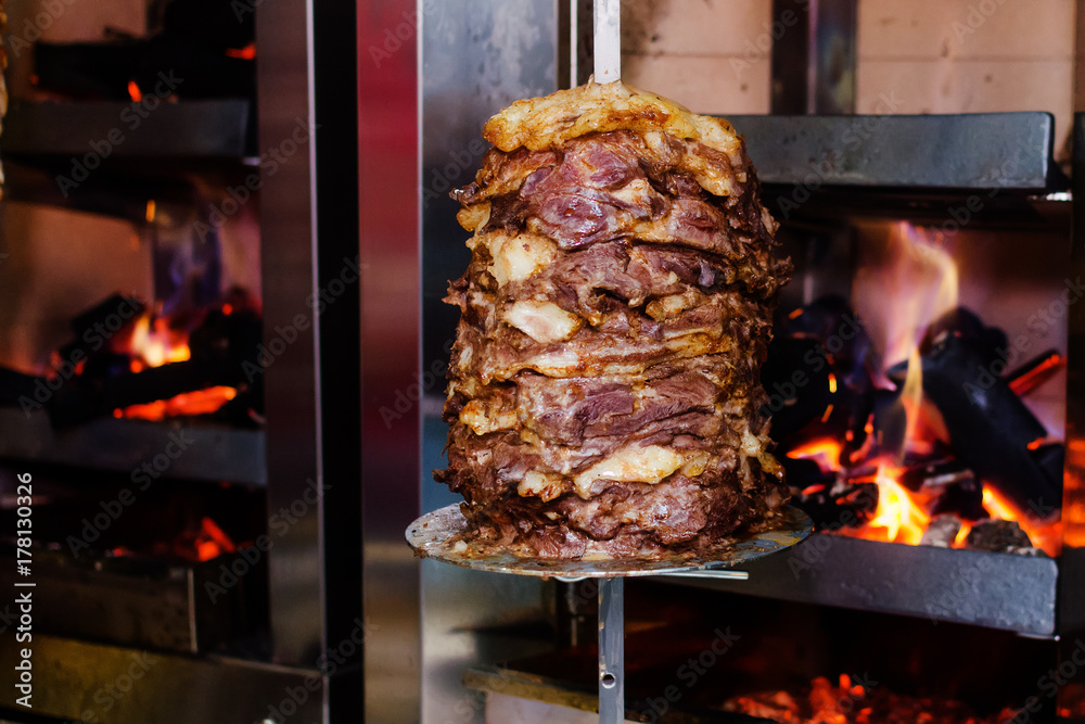 Close up shot of stacked meat roasting to be used in preparation of traditional Greek dish gyros or Turkish durum doner. shawarma Close up shot of stacked meat roasting to be used in preparation of traditional Greek dish gyros or Turkish durum doner. shawarma
