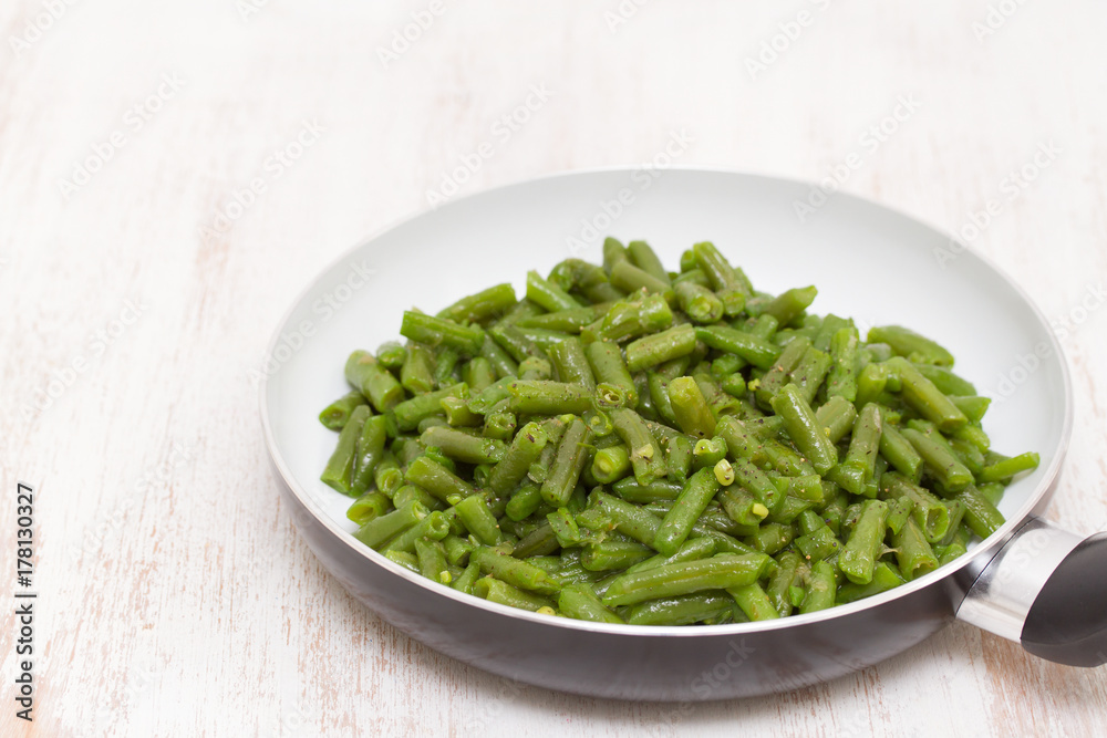green beans on frying pan on wooden background green beans on frying pan on wooden background