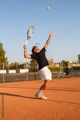 Professional player doing a tennis kick on court in the afternoon. 
