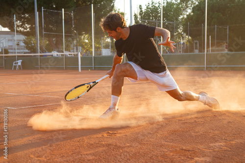 Professional tennis player man playing on court in afternoon.   © pablobenii