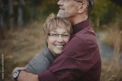 Middle aged woman enjoying a hug from her husband