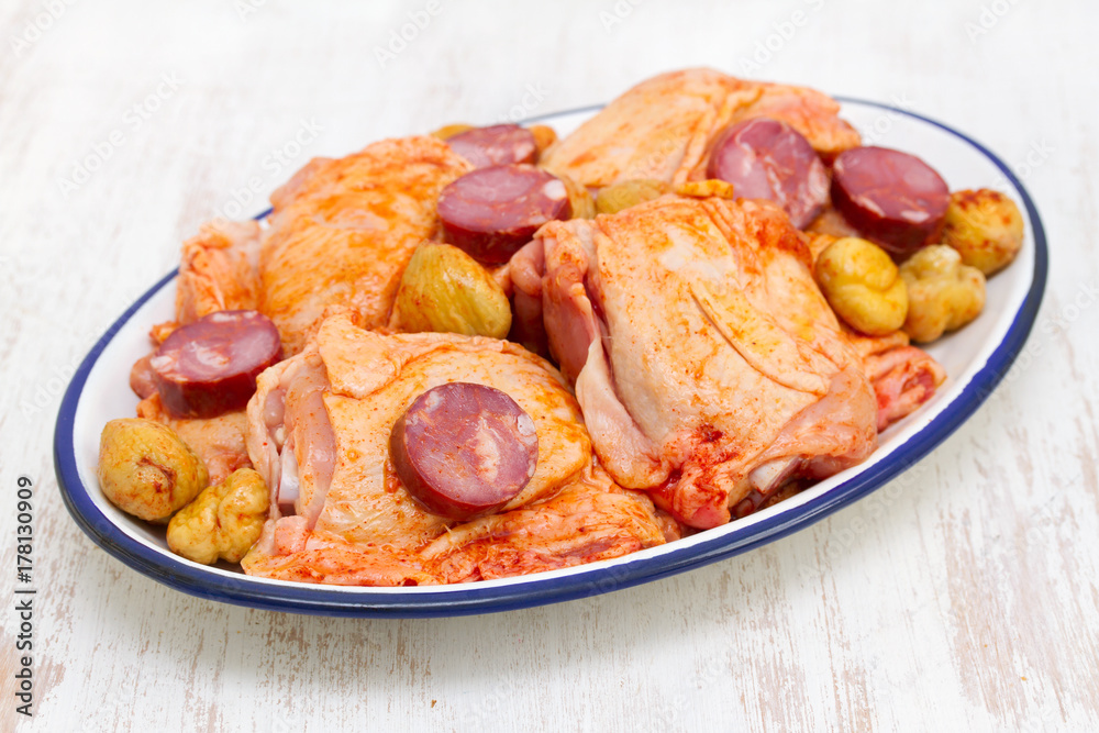 raw marinated chicken with smoked sausages on dish raw marinated chicken with smoked sausages on dish