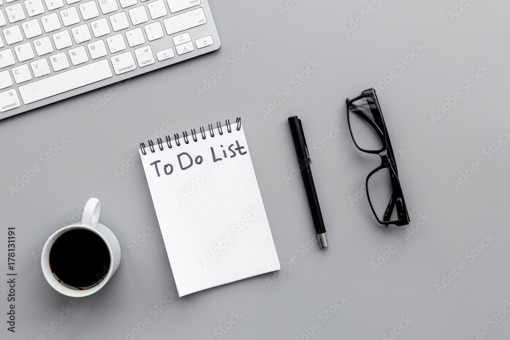 To do list for businessman in notebook on office table. Grey background top view To do list for businessman in notebook on office table. Grey background top view
