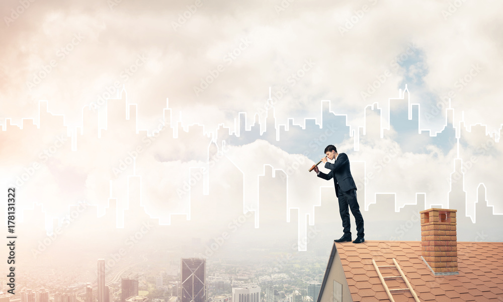Engineer man standing on roof and looking in spyglass. Mixed med Engineer man standing on roof and looking in spyglass. Mixed med