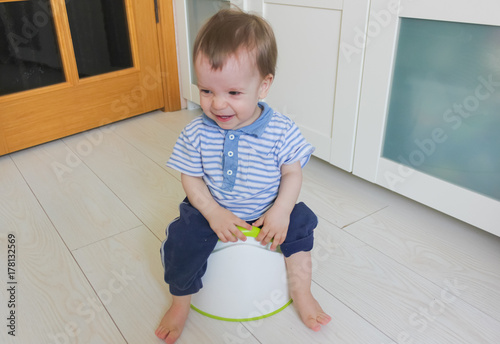 A little boy learns to go potty. Accustom the child to the potty..