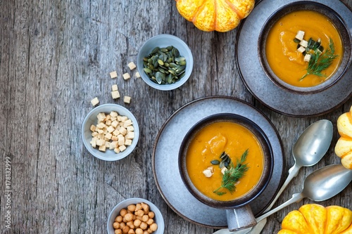 Creamy pumpkin soup topped with pumpkin seeds close-up