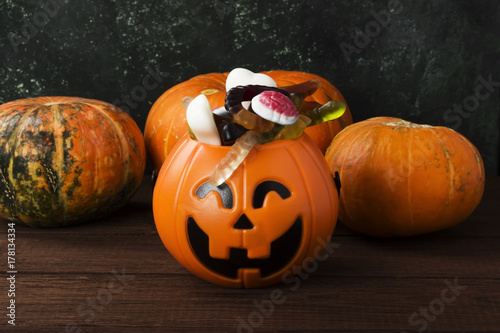 Terrible sweets for Halloween in decorative pumpkin on a dark background