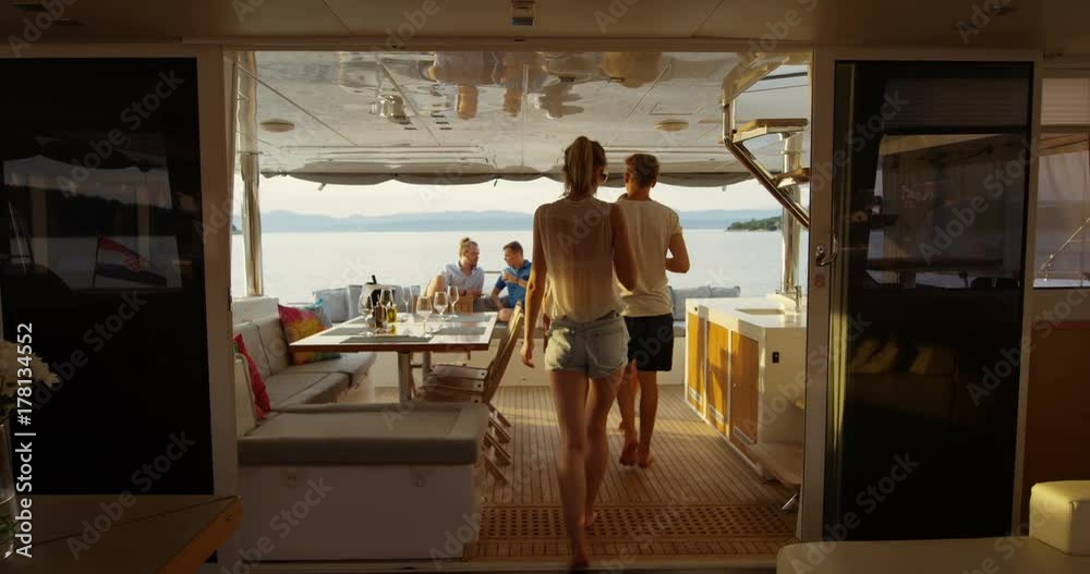 Group of Successful Young People Join Others in the Stern of the Yacht with Cocktails. In the Background Calm Sea and Islands. Shot on RED Epic 4K UHD Camera.