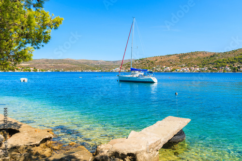 Sailboat on sea and beach with turquoise crystal clear sea water in Rogoznica town, Dalmatia, Croatia