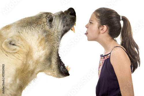 Young fearless girl with a polar bear on a white background photo