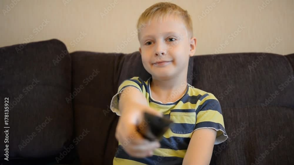 A young schoolboy watches television at home. Emotions, impression, mood A young schoolboy watches television at home. Emotions, impression, mood