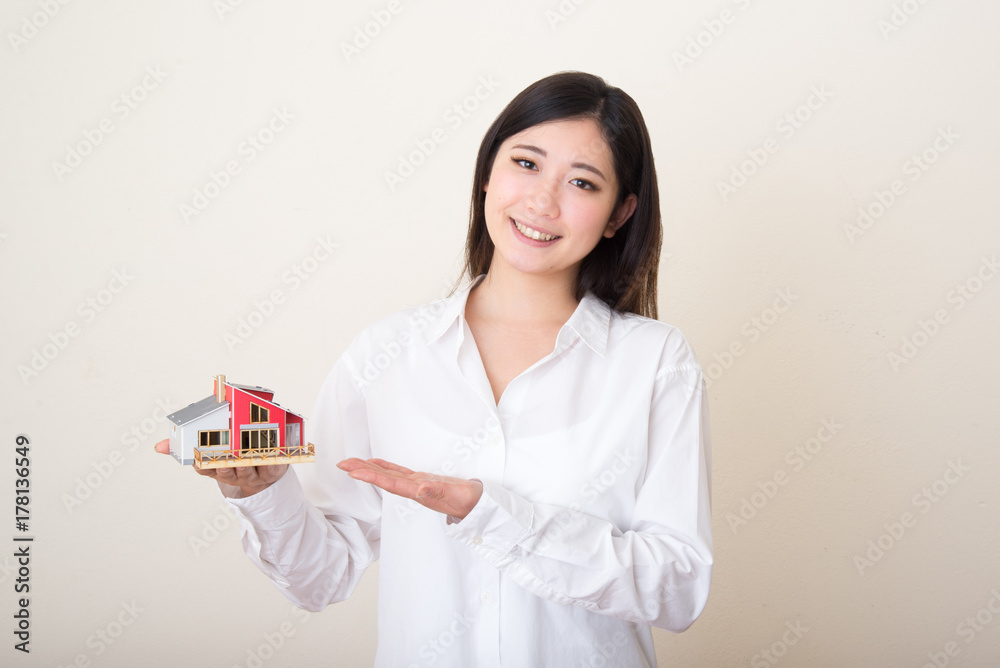 young asian woman with miniture house young asian woman with miniture house