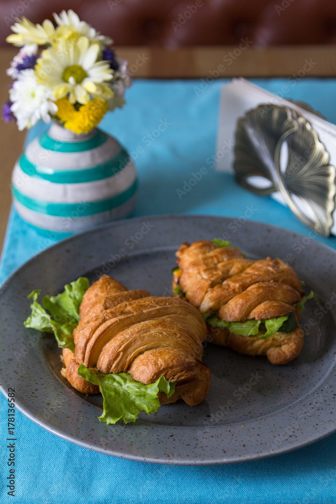 Croissant sandwich with ham on grey plate