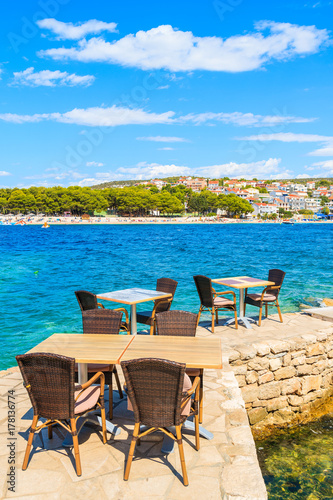 Tables with chairs of coastal bar in Primosten town, Dalmatia, Croatia.