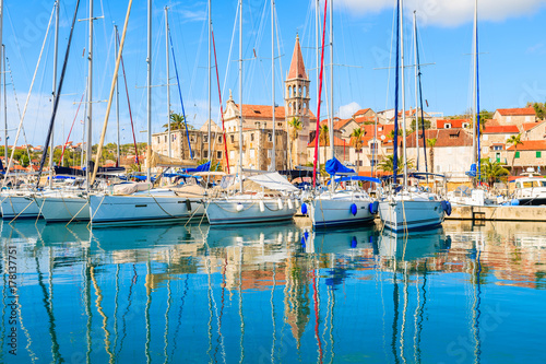 Reflection of sailing boats anchoring in beautiful Milna port with church tow...