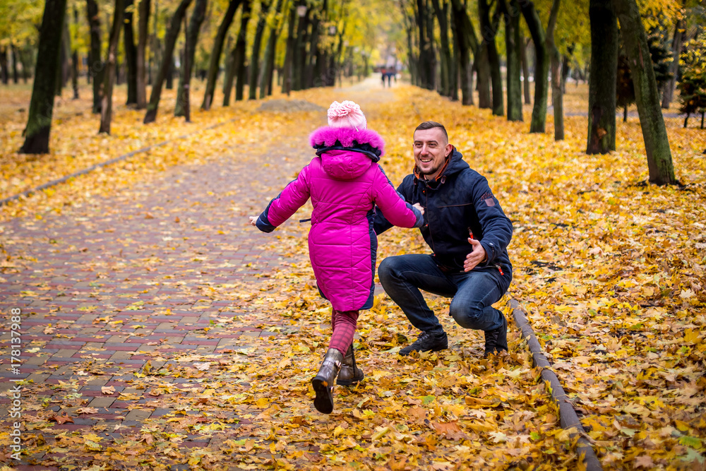 the child runs to meet his father.. A little girl runs through the autumn park to her father's arms. family walking in the forest on a sunny autumn day father and daughter enjoying time together the child runs to meet his father.. A little girl runs through the autumn park to her father's arms. family walking in the forest on a sunny autumn day father and daughter enjoying time together