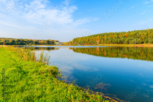 Reflection of colorful trees in small lake in autumn season, Poland