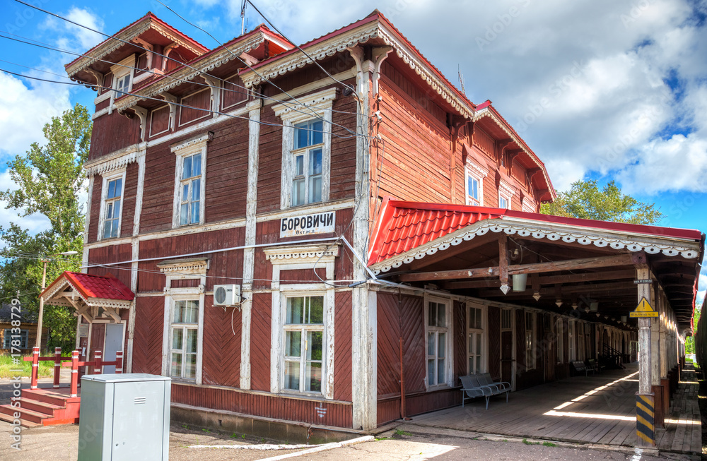 Old wooden provincial railway station with platform in summer sunny day. Novgorod region, Russia Old wooden provincial railway station with platform in summer sunny day. Novgorod region, Russia