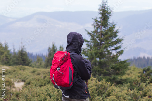 hiker with red backpack alone in the autumn mountains 