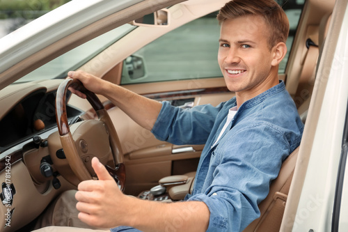 Young man on driver seat of...