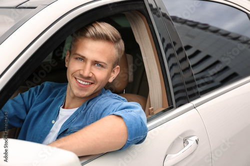 Young man on driver seat of...
