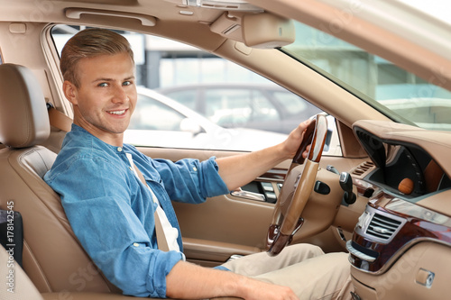 Young man on driver seat of...