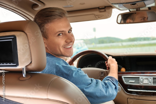 Young man on driver seat of...