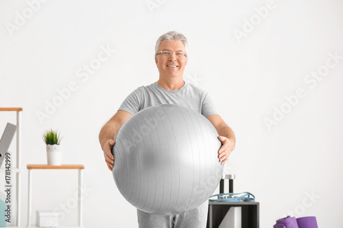 Senior man with fitball in ...